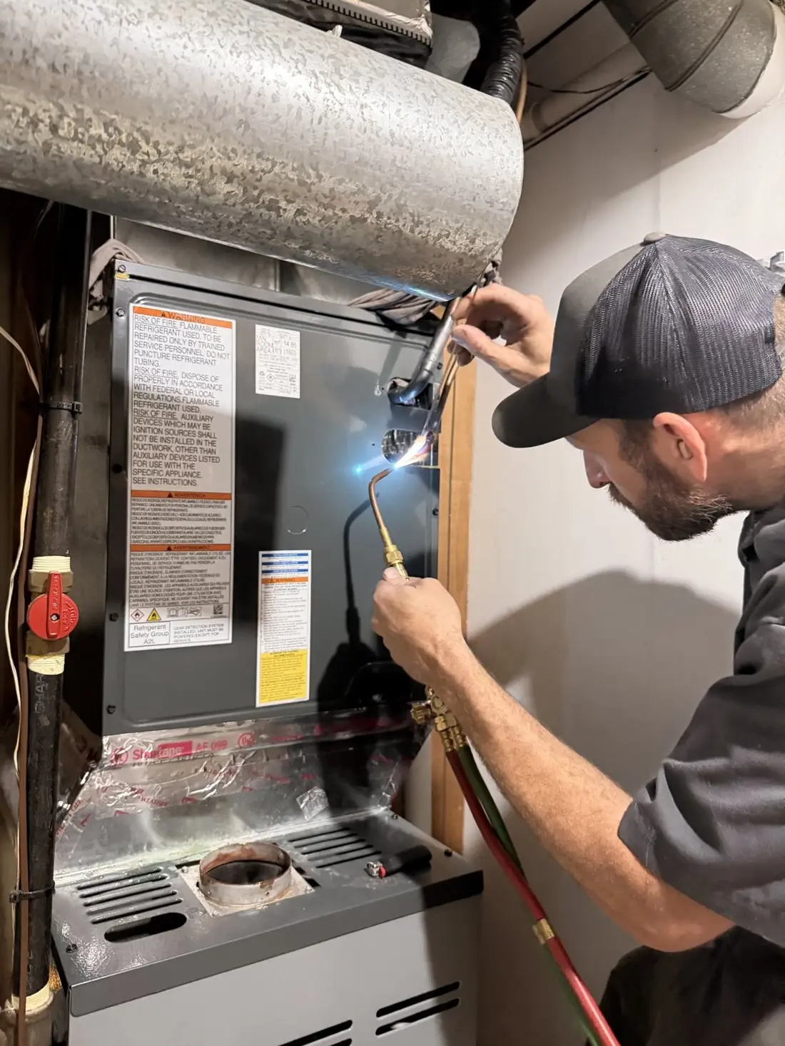 A Furnace Direct installer brazing a line set on a furnace